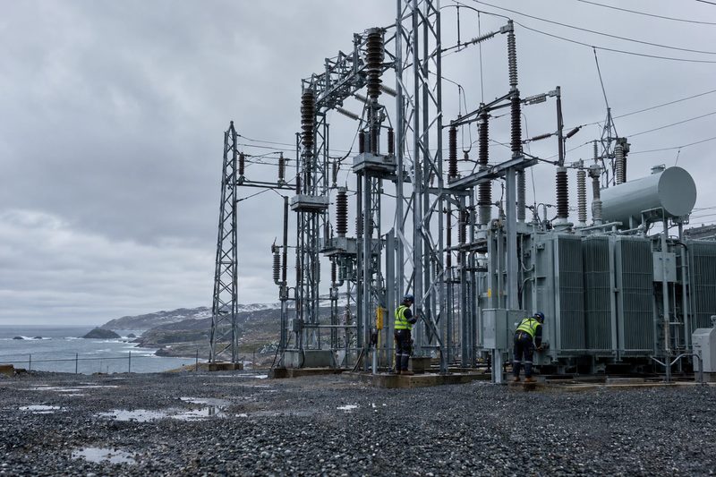 Electricians at an outdoor substation on the coast